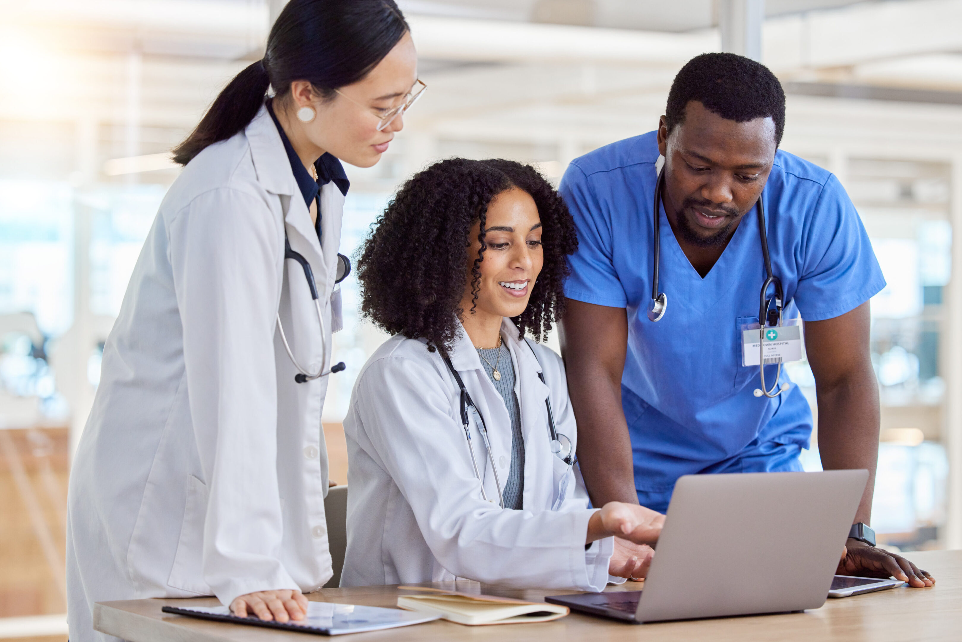 Laptop, group collaboration or doctors reading healthcare results, online clinic feedback or medicine report. Hospital diversity, communication or medical nurse, surgeon or staff teamwork on research Restore Health Family Practice